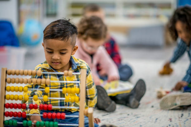 Young boy playing with a wooden abacus toy