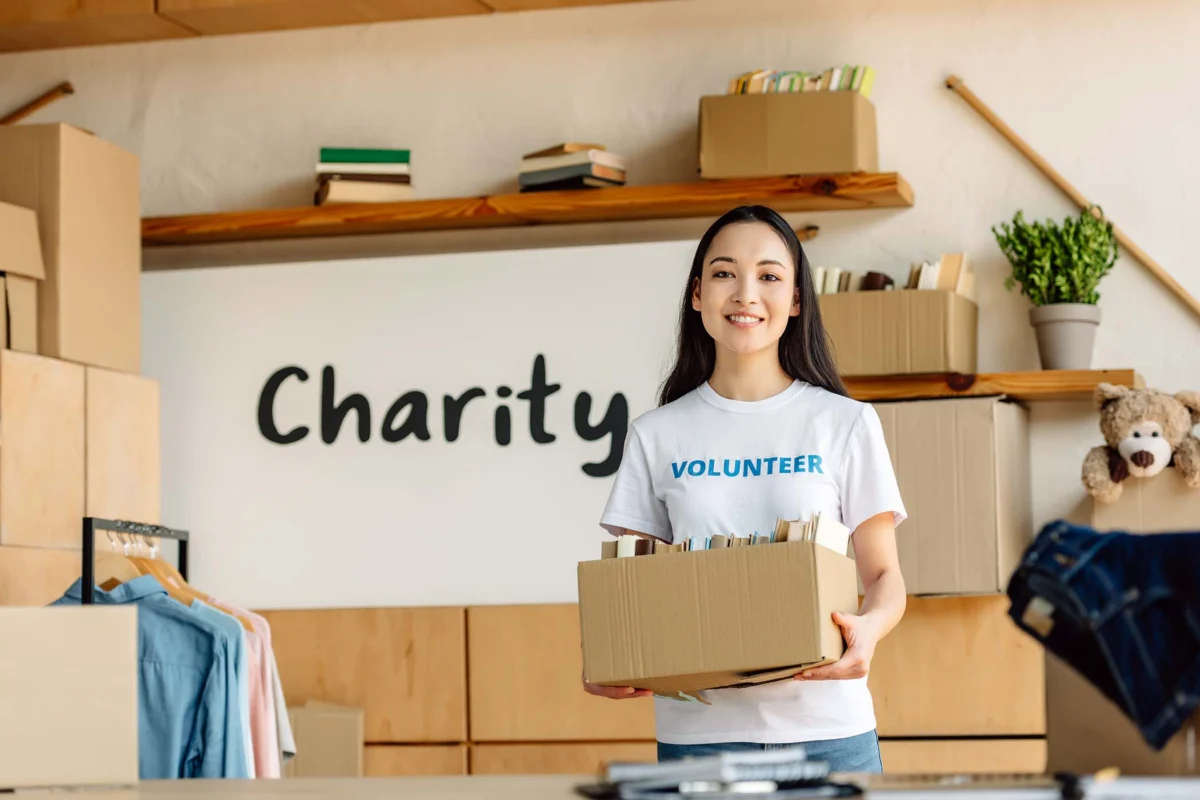 Volunteer holding a cardboard box of donations